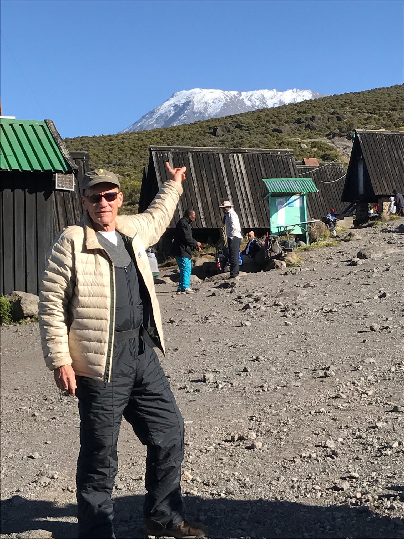 Lori's father, George, pointing toward Mount Kilimanjaro during his climb