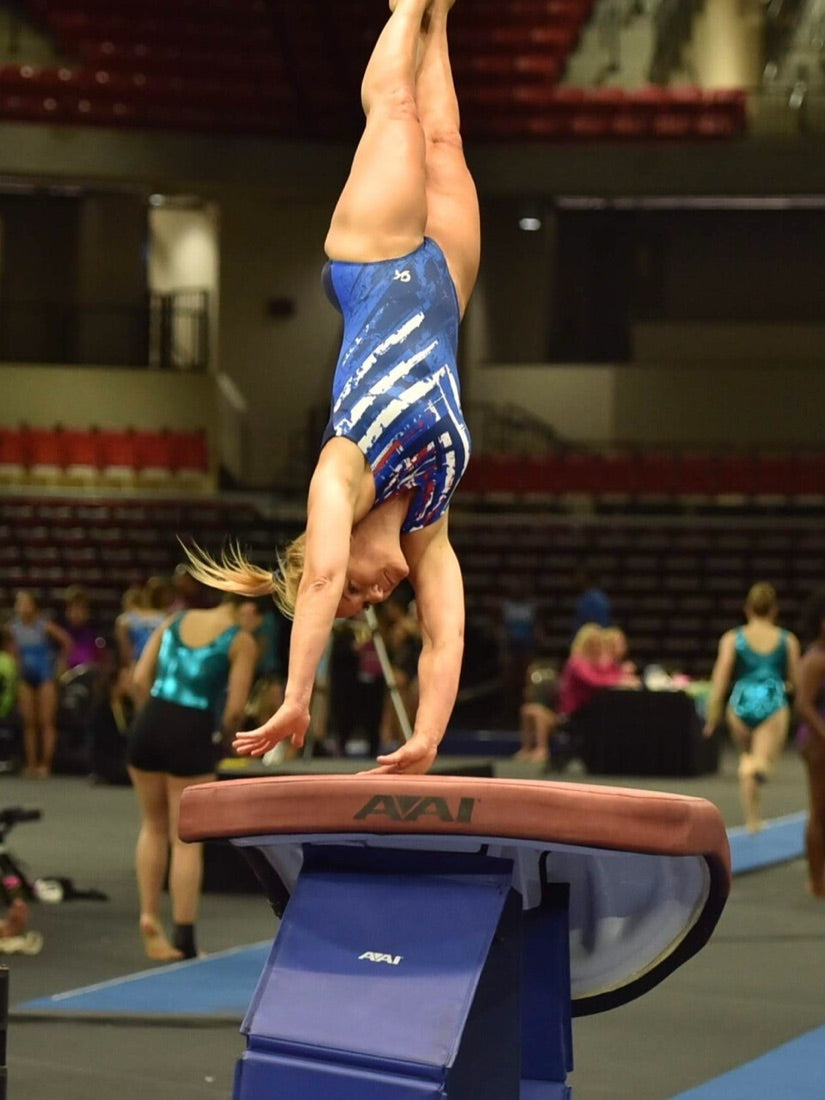 Lori Vollkommer inverted above the vault table during a gymnastics competition